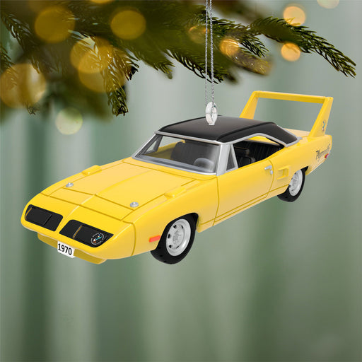 Yellow car ornament hanging on a Christmas tree with a green background