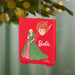 Barbie ornament with a red background featuring the Barbie character and logo, hanging on a Christmas tree.