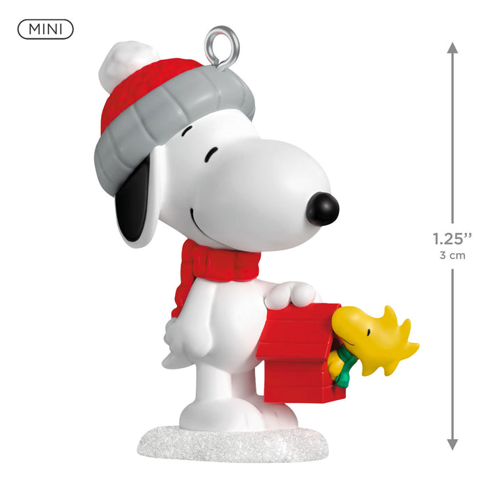 Snoopy figurine with a red hat and scarf, holding Woodstock, on a white background with dimensions indicated.