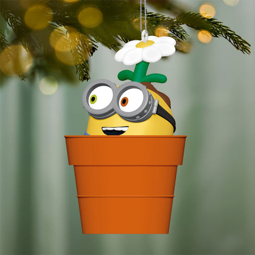 Decorative ornament shaped like a character in a pot with a flower, hanging on a tree branch.