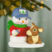 Decorative ornament of a snowman with a calf and baby bottle, hanging on a Christmas tree.