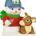 Snowman with a blue cap and red sweater holding a bottle, standing next to a calf on a white background