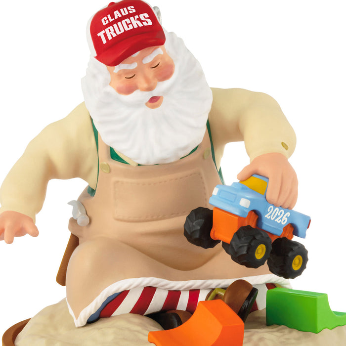Toy figure of Santa Claus in overalls holding a toy truck with 'Claus Trucks' branding.
