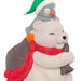Polar bear figurine with a penguin on its back, both wearing Christmas hats and scarves.