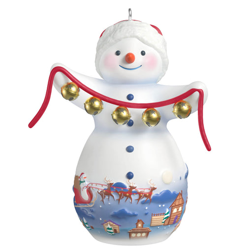Decorative snowman ornament with jingle bells and a Santa Claus scene on a white background