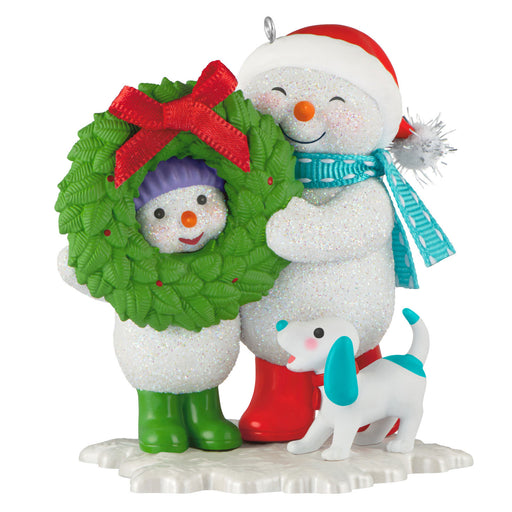 Christmas ornament featuring two snowmen with a wreath and a dog on a white background