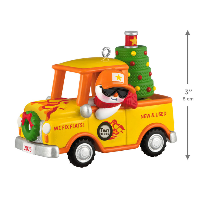 Christmas ornament of a yellow truck with a snowman driver and Christmas tree on a white background