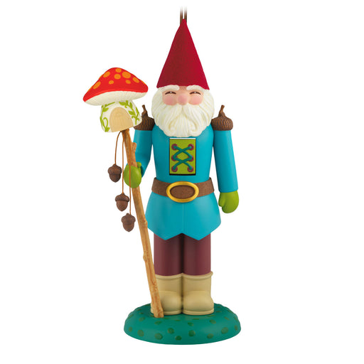 Colorful gnome figurine with a red hat and blue outfit with a mushroom-topped staff in hand on a white background