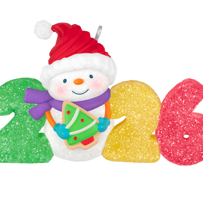 Decorative ornament shaped like the number 24 with a snowman design, holding a Christmas tree cookie.