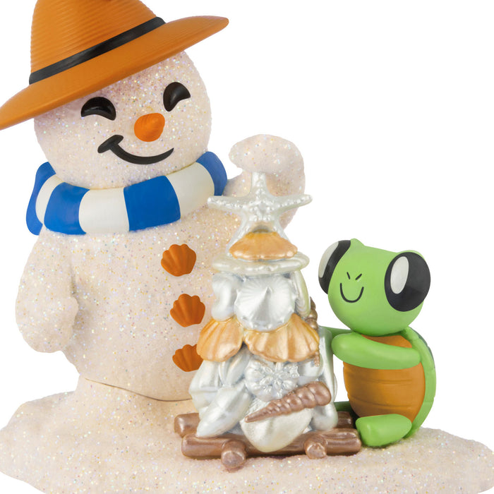 Decorative snowman figurine with a turtle and small house on a white background