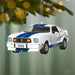 Christmas ornament shaped like a classic car with blue stripes, hanging from a tree.