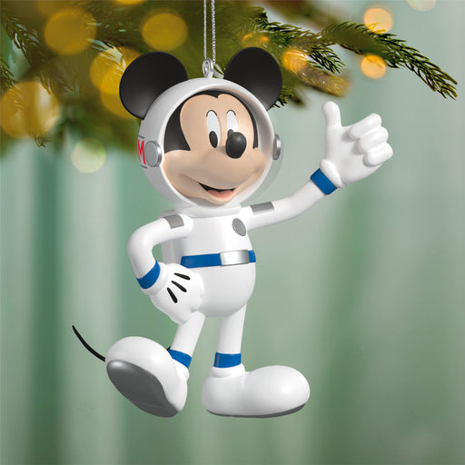 Mickey Mouse astronaut ornament on a Christmas tree with blurred lights in the background