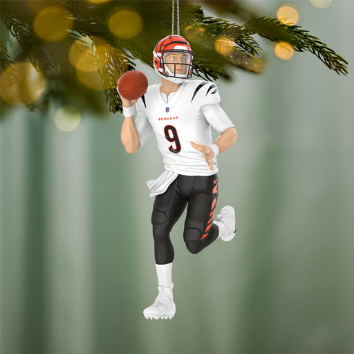 Football player ornament with helmet and jersey, hanging on a Christmas tree.