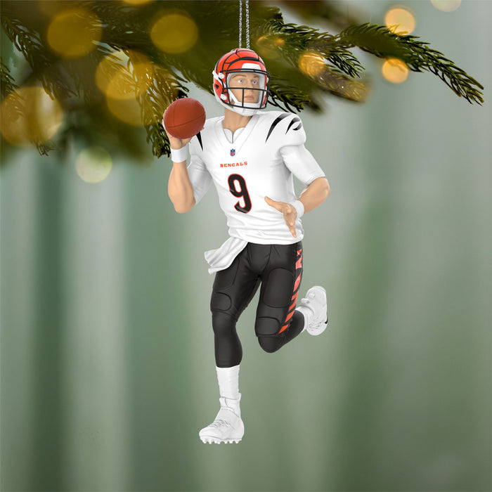 Football player ornament with helmet and jersey, hanging on a Christmas tree.
