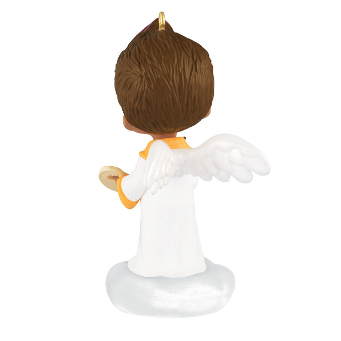 Small figurine of an angel with brown hair and white outfit on a white background