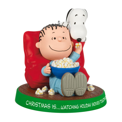 Figurine of a character watching TV with a bowl of popcorn, sitting on a red chair, with Snoopy on their head, on a white background.