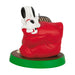 Dog figurine on a red pillow with a green base on a white background