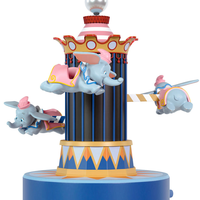 Decorative figurine of Dumbo the elephant on a carousel with a white background