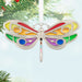 Colorful butterfly-shaped ornament hanging on a Christmas tree.