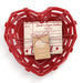 Red heart-shaped cookie tray with baking ingredients and recipe card on a white background