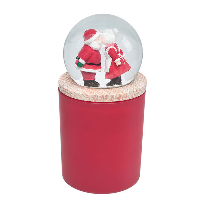 Snow globe with Santa and reindeer design on a red cylindrical stand with wooden top.
