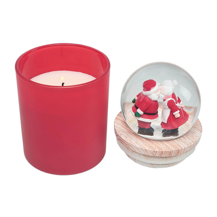 Red candle and a snow globe with Santa Claus and a reindeer on a white background