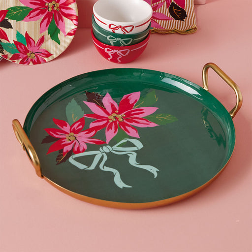 Green tray with poinsettia design on a pink surface