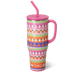 Colorful Halloween-patterned tumbler with pink handle and straw on a white background