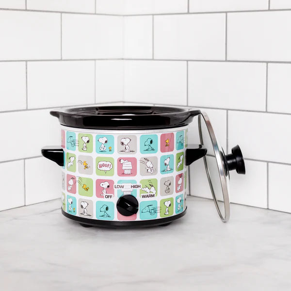 Small slow cooker with colorful design on a white surface against a tiled wall.