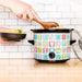 Multicolored electric rice cooker with cartoon designs on a kitchen counter.