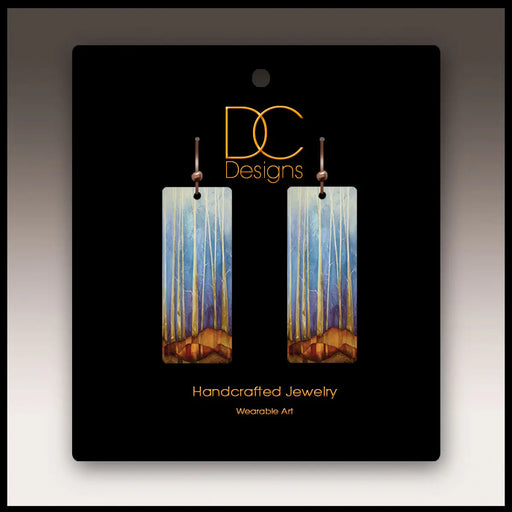 Pair of earrings on a black card with 'DC Designs' branding