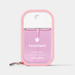 A pink silicone protective case for a Touchland Power Mist hand sanitizer, featuring a white cap, clear bottle showing pink liquid, and a silver keychain ring, on a light gray background.