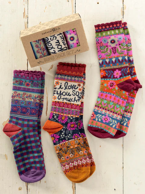 Colorful patterned socks with a 'I love you so much' message on a wooden surface