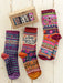Colorful patterned socks with a 'I love you so much' message on a wooden surface