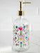 Glass soap dispenser with floral design and gold pump on a white background