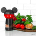 Disney Mickey Mouse-themed pepper grinder on a kitchen counter with vegetables and bread.