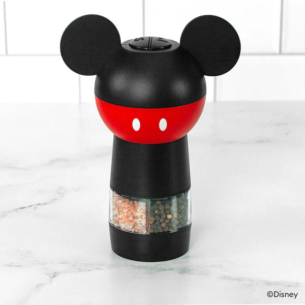 Mickey Mouse-themed pepper grinder on a marble surface with a white tiled background