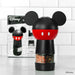 Mickey Mouse-themed pepper grinder on a tiled kitchen counter with Disney packaging in the background.