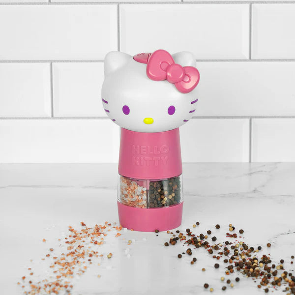 Hello Kitty-themed pink pepper grinder on a white surface with a tiled wall background