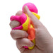 Hand holding a colorful stress ball with pink, yellow, and orange colors on a white background.