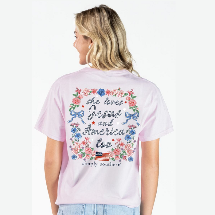 Woman wearing a pink t-shirt with floral and text design, standing against a white background.