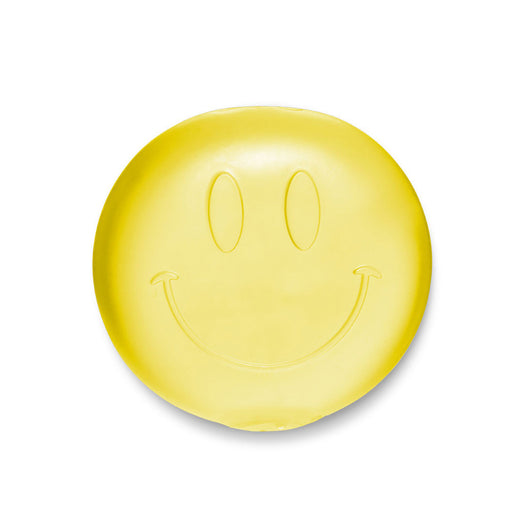Yellow bar of soap with a smiley face design on a white background