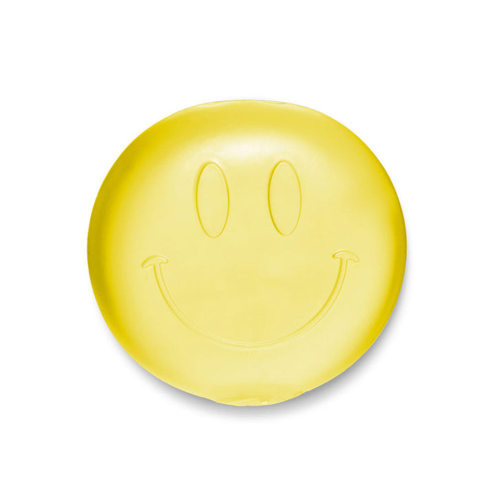 Yellow bar of soap with a smiley face design on a white background