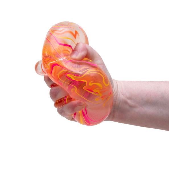 Hand holding a marbled orange and pink stress ball against a white background