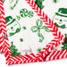 A close-up of a white plush blanket with a festive Christmas print featuring green snowmen, candy canes, pine trees, and a red-and-white striped border.