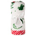A rolled white plush blanket with green embroidered holiday motifs and a red-and-white striped hem, tied with a white ribbon and a small paper tag, on a white background.
