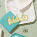 Decorative card with 'Celebrate' text, teal envelope, and geometric design on a light green background.
