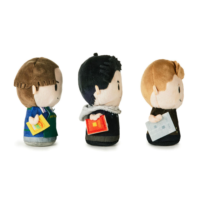 Three small plush character figures shown from the back on a clean white background. Each figure has a different hairstyle and outfit, with one holding a yellow item, one holding an orange item, and one holding a light blue item.