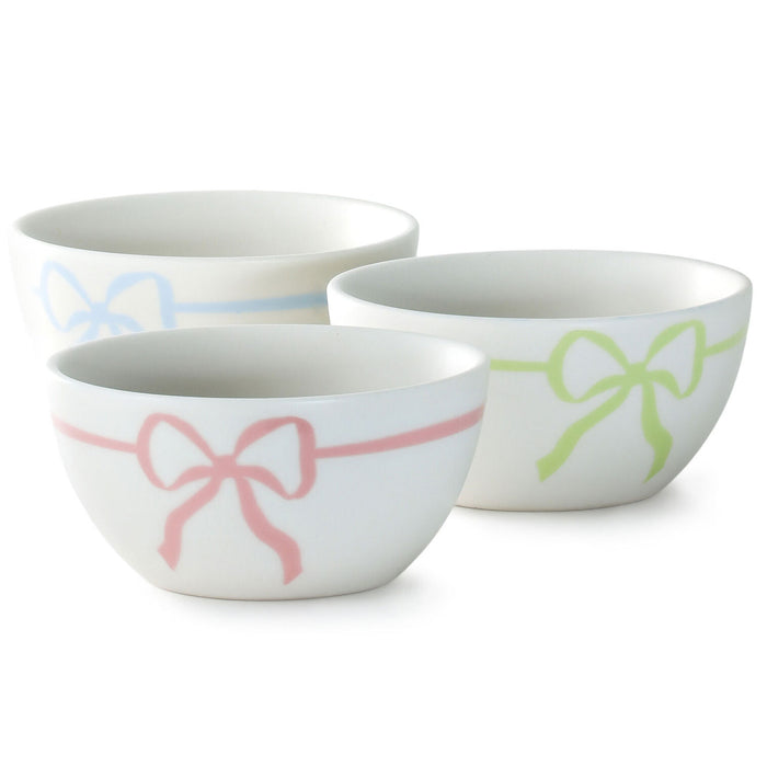 Set of three ceramic bowls with colorful bow designs on a white background