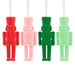 Four nutcracker-shaped candles in red, pink, green, and light green on a white background.